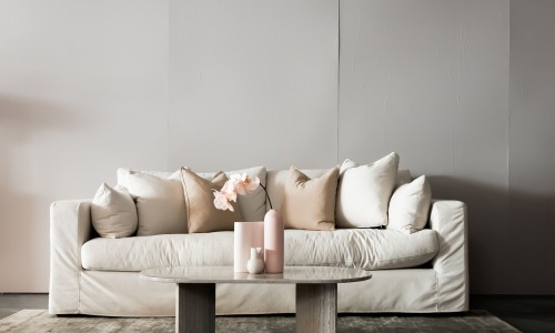 living room with a large couch and vases on a coffee table